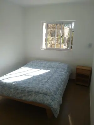 a bed in a bedroom with a window at Casa de Vacaciones in Santa Rosa de Calamuchita