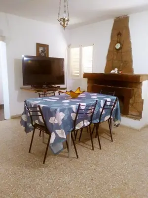 a living room with a table and a piano at Casa de Vacaciones in Santa Rosa de Calamuchita