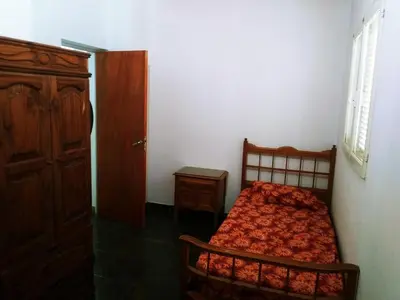 a bedroom with a bed and a wooden door at Casa de Vacaciones in Santa Rosa de Calamuchita