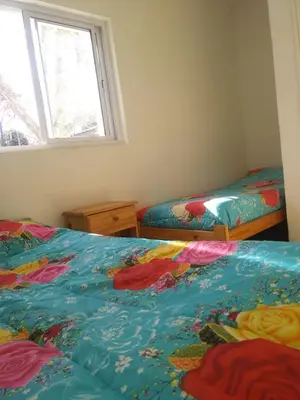 a bedroom with two beds and a window at Casa de Vacaciones in Santa Rosa de Calamuchita