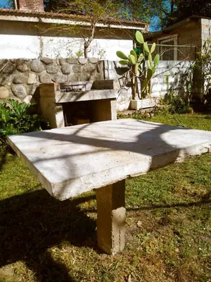 a stone bench sitting in the grass in a yard at Casa de Vacaciones in Santa Rosa de Calamuchita