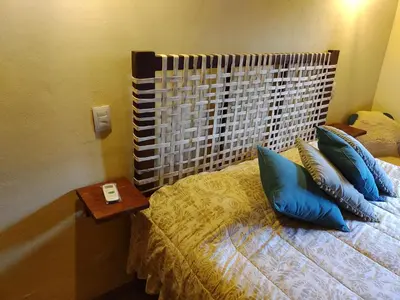a bedroom with a bed with blue pillows and a table at La Morada, imperdible Casa de Campo en La Matilde in San Javier