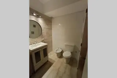 a bathroom with a toilet and a sink and a mirror at Descanso El Parque depto 420 in Cordoba