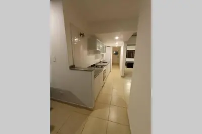a kitchen with white cabinets and a tile floor at Descanso El Parque depto 420 in Cordoba