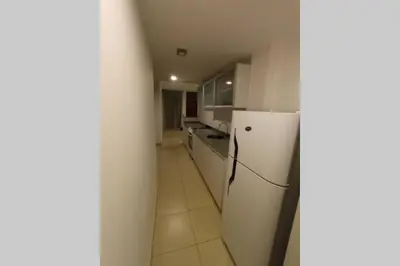 a kitchen with white cabinets and a refrigerator at Descanso El Parque depto 420 in Cordoba
