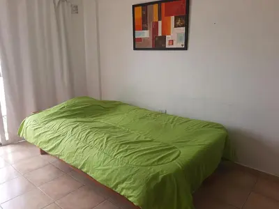 a green bed in a room with a picture on the wall at Plaza Rivadavia Departamento in Cordoba