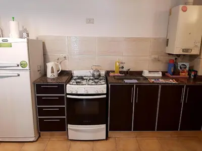 a kitchen with a stove and a white refrigerator at Plaza Rivadavia Departamento in Cordoba