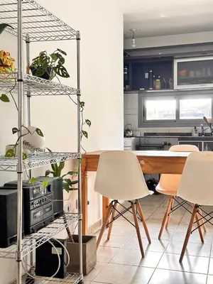 a kitchen with white chairs and a table with plants at Departamento Ecofriendly excelente ubicación in Cordoba