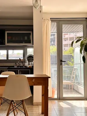 a kitchen with a table and a sliding glass door at Departamento Ecofriendly excelente ubicación in Cordoba