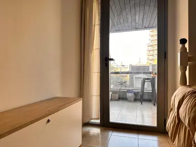 a bedroom with a door open to a balcony at Departamento Ecofriendly excelente ubicación in Cordoba