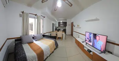 a bedroom with a bed and a flat screen tv at Departamentos Premium Miralejos 3 in Villa Carlos Paz