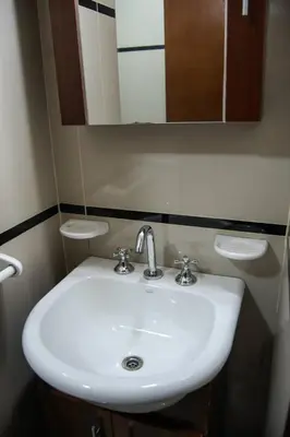 a bathroom with a white sink and a mirror at Departamentos Premium Miralejos 3 in Villa Carlos Paz