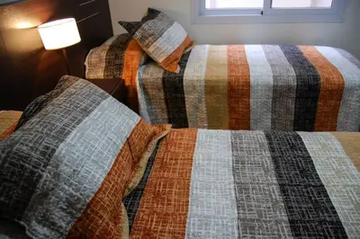 two beds sitting next to each other in a room at Departamentos Premium Miralejos 3 in Villa Carlos Paz