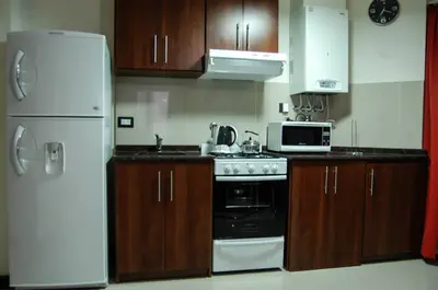 a kitchen with a white refrigerator and a stove at Departamentos Premium Miralejos 3 in Villa Carlos Paz