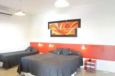 a bedroom with two beds and a painting on the wall at Hotel Ritz in Alta Gracia