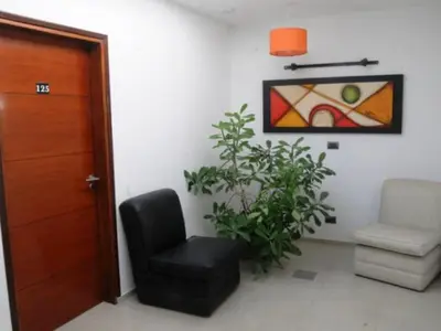 a living room with a chair and a plant at Hotel Ritz in Alta Gracia