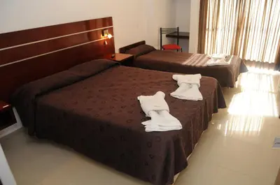 a hotel room with two beds with white shoes on them at Hotel Ritz in Alta Gracia