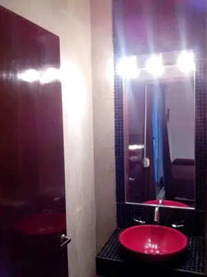 a bathroom with a red sink and a mirror at Hotel Ritz in Alta Gracia
