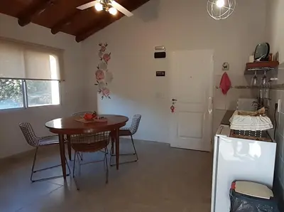 a kitchen with a table and chairs in a room at COSTA COM Apart Suites in Merlo
