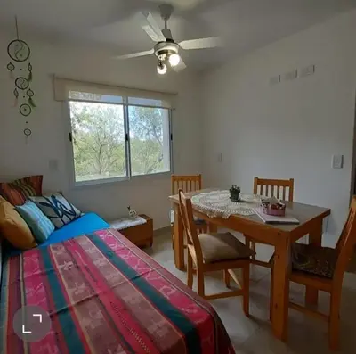 a bedroom with a bed and a table and chairs at COSTA COM Apart Suites in Merlo