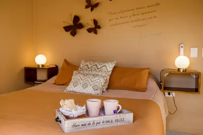 a bedroom with a bed with a tray with cups on it at COSTA COM Apart Suites in Merlo