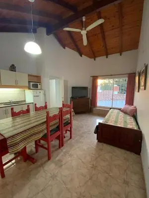 a living room with a table and chairs and a kitchen at condominio La Inesita in Villa Carlos Paz