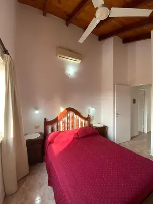 a bedroom with a bed with a red bedspread at condominio La Inesita in Villa Carlos Paz