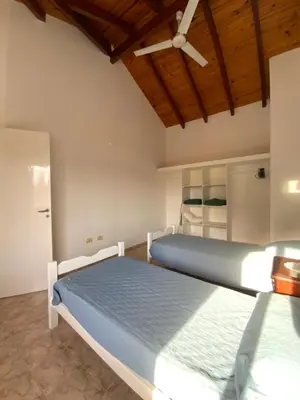a bedroom with two beds and a ceiling fan at condominio La Inesita in Villa Carlos Paz