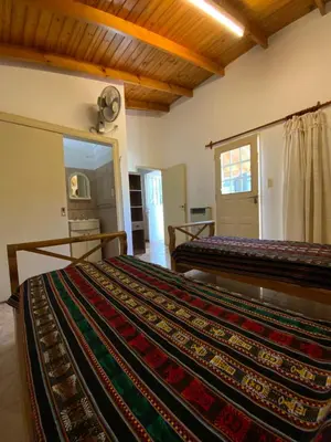 a bedroom with two beds and a mirror at condominio La Inesita in Villa Carlos Paz