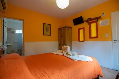 a bedroom with an orange bed with a stuffed animal on it at El Viejo Algarrobo - Hosteria Serrana in Merlo