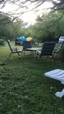 a group of chairs and a picnic table in the grass at Monte in Los Manantiales