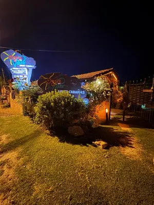 a building with a sign on it at night at Apart Cabañas Oasis del Valle in Villa Cura Brochero