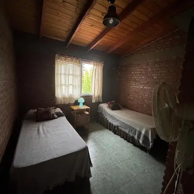 a room with two beds and a window in it at Apart Cabañas Oasis del Valle in Villa Cura Brochero