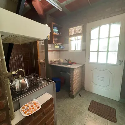 a kitchen with a stove and a sink at Apart Cabañas Oasis del Valle in Villa Cura Brochero