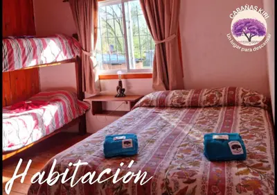 a bedroom with a bed with two bags on it at Cabañas Kiri in Santa Rosa de Calamuchita