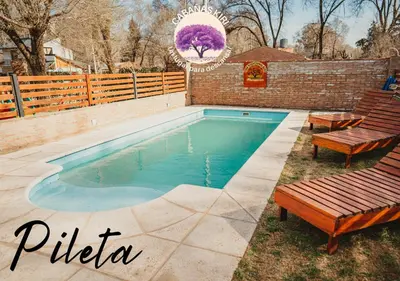 a swimming pool with two benches next to a fence at Cabañas Kiri in Santa Rosa de Calamuchita
