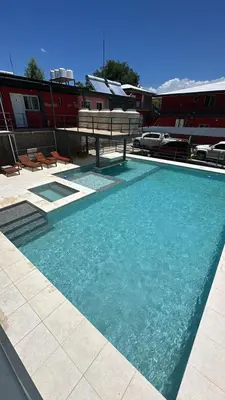 a swimming pool with a table and benches in a building at La posta del vasco in Tanti