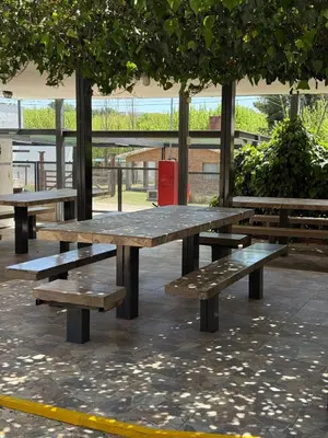 a group of picnic tables in a park at La posta del vasco in Tanti