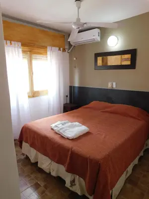 a bedroom with a bed with two towels on it at Hotel Posada Del Lago in Villa Carlos Paz