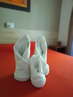 a pair of white shoes sitting on top of a bed at Hotel Posada Del Lago in Villa Carlos Paz