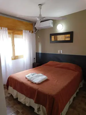 a bedroom with a bed with two towels on it at Hotel Posada Del Lago in Villa Carlos Paz