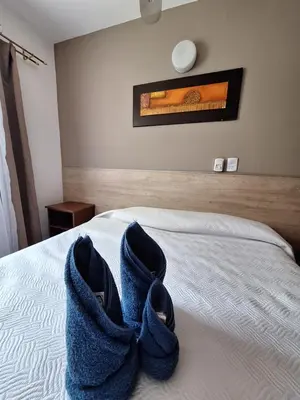 a bedroom with a bed with blue towels on it at Hotel Posada Del Lago in Villa Carlos Paz