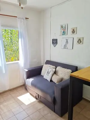 a blue couch in a living room with a window at Dto Marian Dean funes 2515 Alto Alberdi in Cordoba