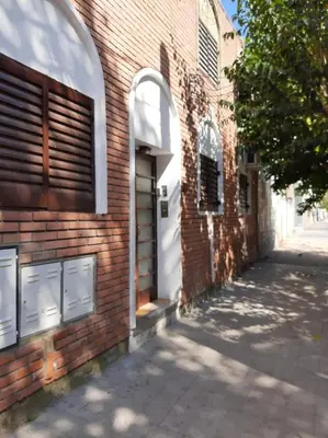 a brick building with a white door on a street at Dto Marian Dean funes 2515 Alto Alberdi in Cordoba