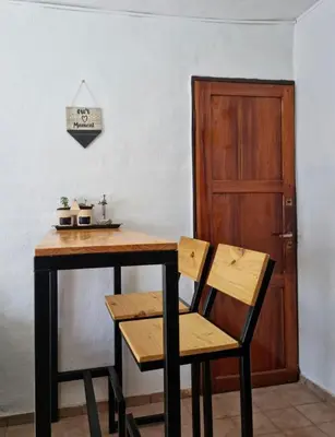 a wooden table with two chairs and a wooden door at Dto Marian Dean funes 2515 Alto Alberdi in Cordoba