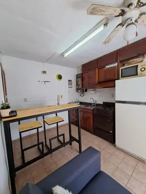 a kitchen with a table and a white refrigerator at Dto Marian Dean funes 2515 Alto Alberdi in Cordoba