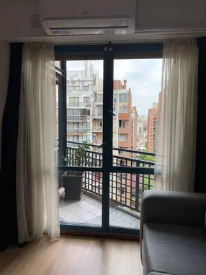 a living room with a large window and a balcony at Salguero Residential Apartament in Cordoba