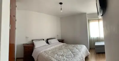 a white bedroom with a bed and a window at Salguero Residential Apartament in Cordoba