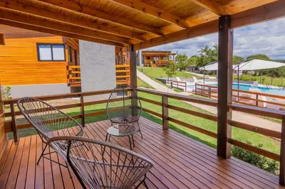 a porch with two chairs and a swimming pool at Monviso - Casas de montaña in Santa Rosa de Calamuchita