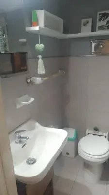 a bathroom with a white sink and a toilet at Abuelito dime tu in Mina Clavero